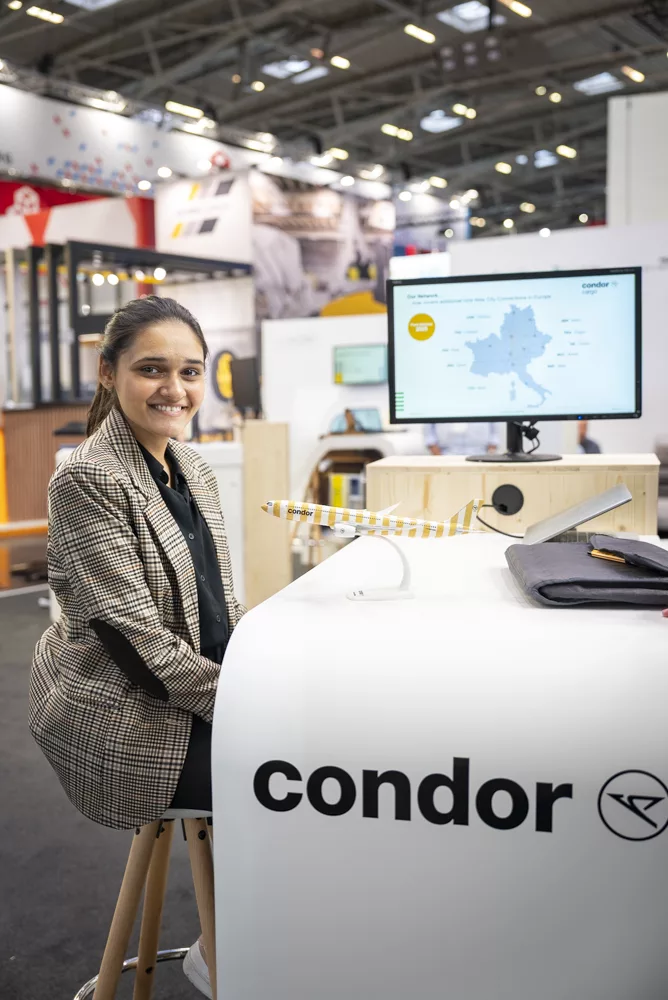 eventfotograf muenchen Frau am Messestand mit Laptop und Flugzeugmodell